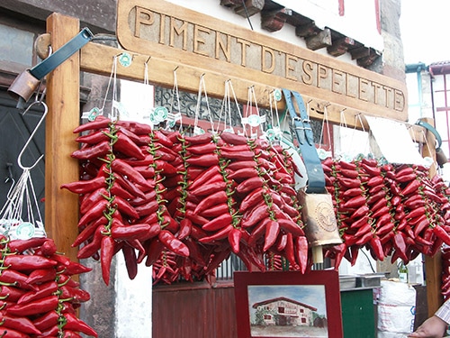 Pepers hangen aan draden in een marktstal in Les Landes.