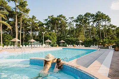 Een vrouw en kind in het zwembad van naturisten camping Arnoutchot in Frankrijk. 
