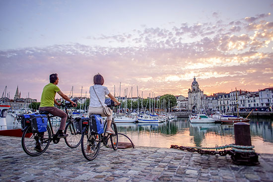 Twee fietsers bewonderen de zonsondergang in La Rochelle