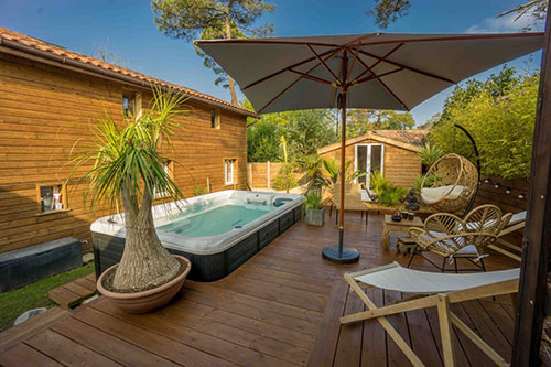 Een hottub en strandstoelen in een lodge in Landes.