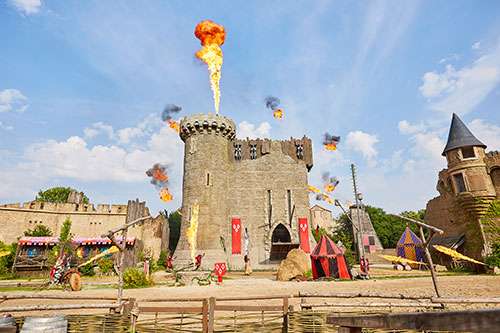 Een kasteel waar vuur uitspuit in het pretpark Puy du Fou.