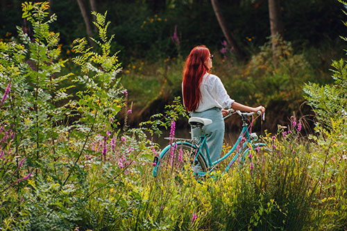 Een vrouw staat naast een fiets in de natuur van het vogelreservaat in het Marais Poitevin.